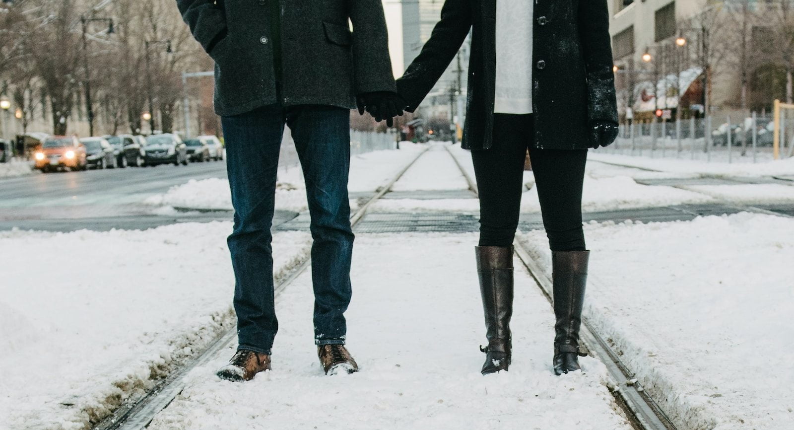 photo of two person standing on snow-covered road