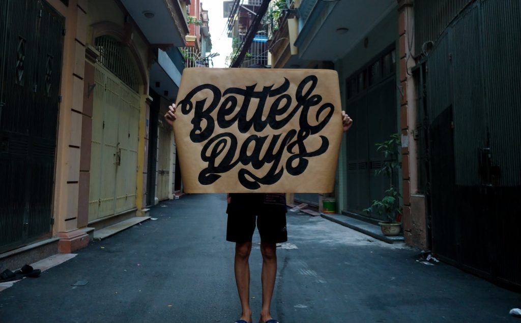woman in black dress standing on sidewalk during daytime