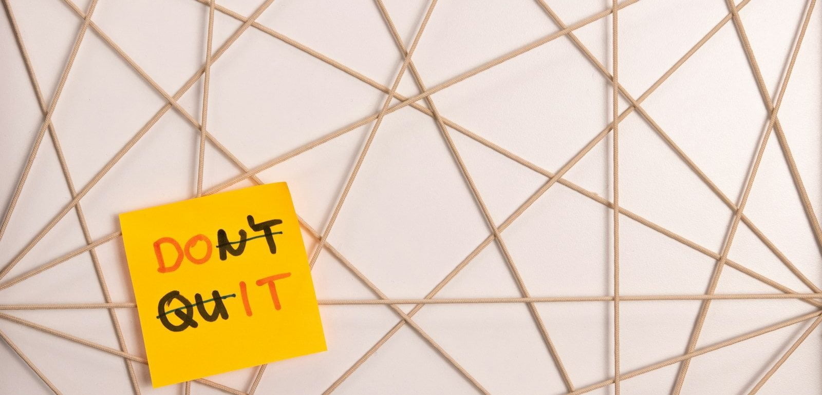 a yellow sign on a white tiled surface