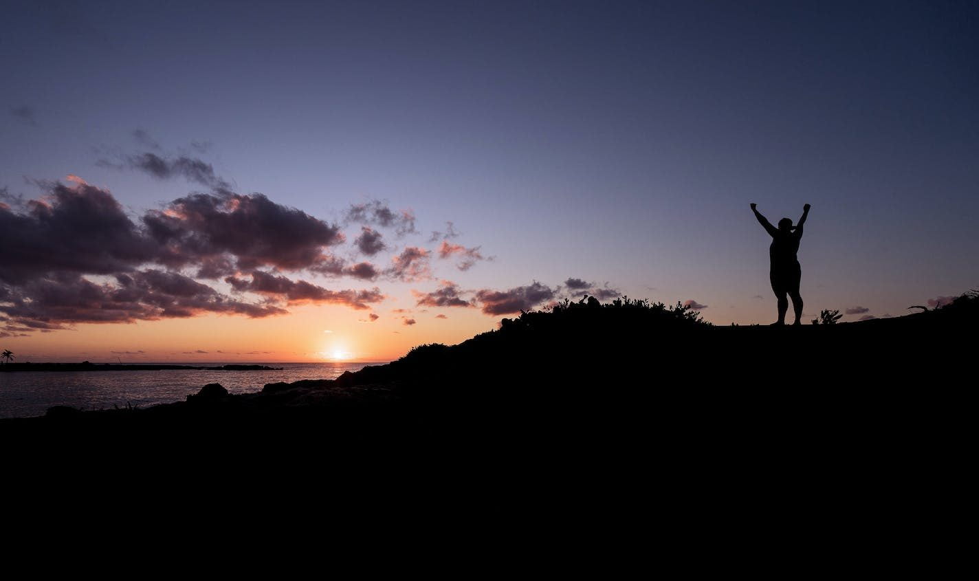 Silhouette of Person Raising Hands